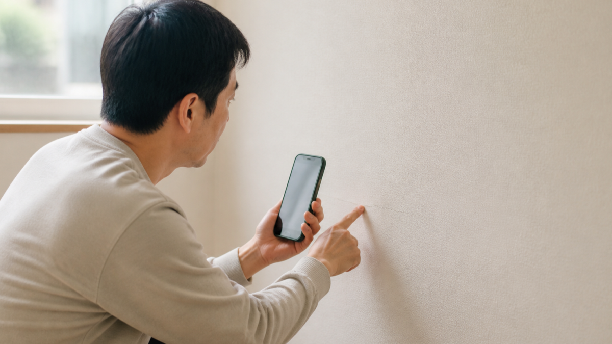 スマートフォンで住宅修理を依頼する様子