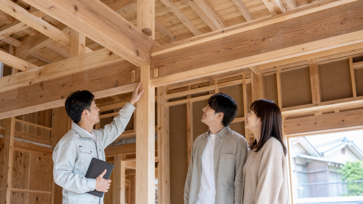 木造住宅の見学会で説明を聞く家族